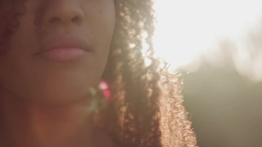 A woman is standing outdoors at dusk