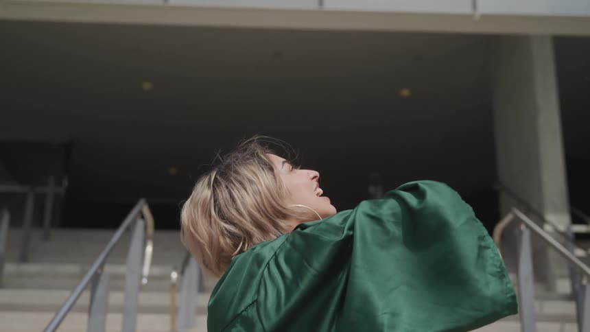 A graduate throws her cap in the air