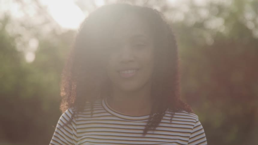 A woman is smiling outdoors