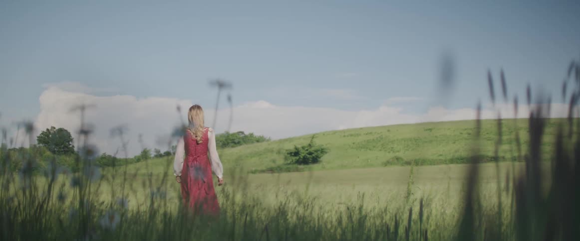 A woman is walking through the grass
