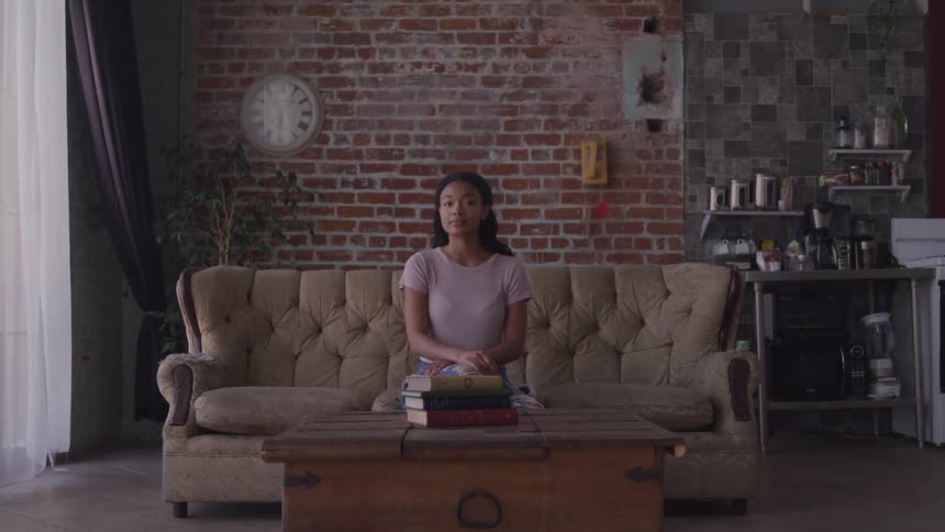 A woman is sitting on a couch indoors