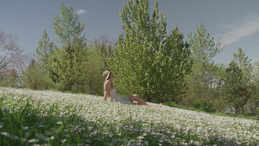 A woman is resting on the hill covered with flowers