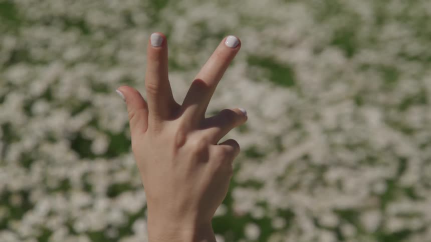 A girl holds her hand up in the air and moves it around
