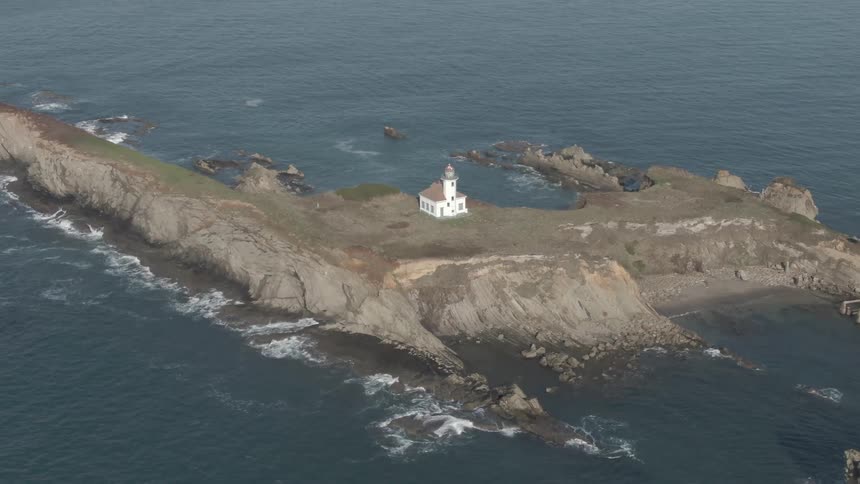 A lighthouse on a peninsula during the day
