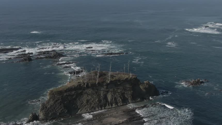 Flying over the ocean looking at rocks and waves
