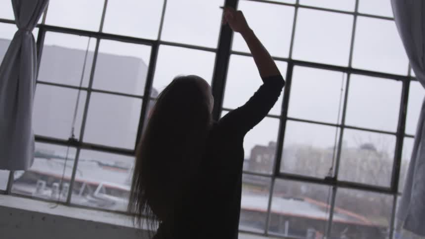 A woman dancing in front of a window