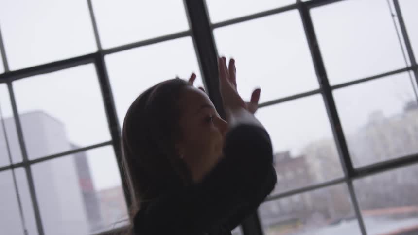 A woman dancing in front of a window