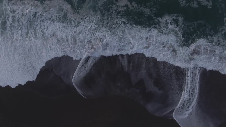 Birds eye view of waves crashing to the shore