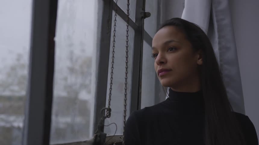 A woman is staring out a window