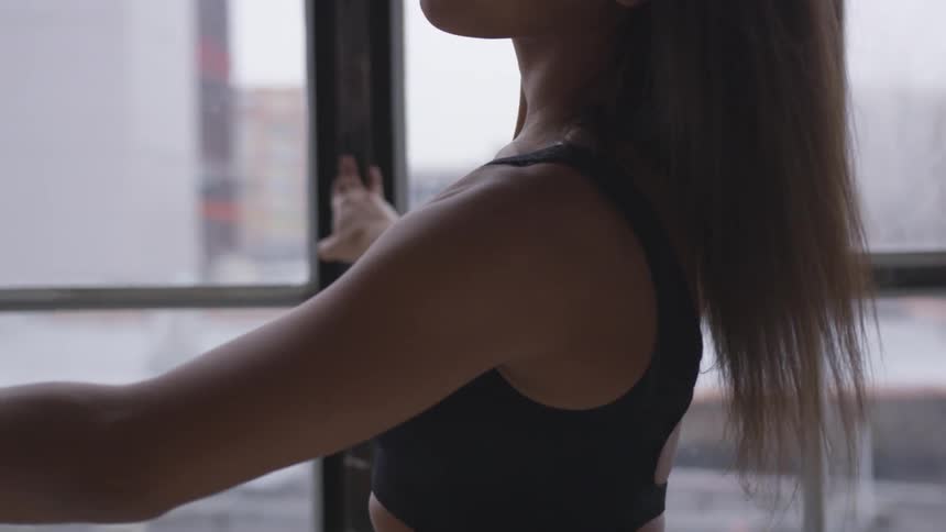 A female inside a room practicing dance moves