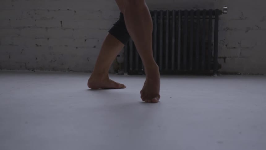 Dancer does footwork on floor near window