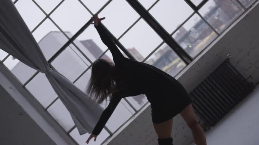 A young woman dancing inside a building