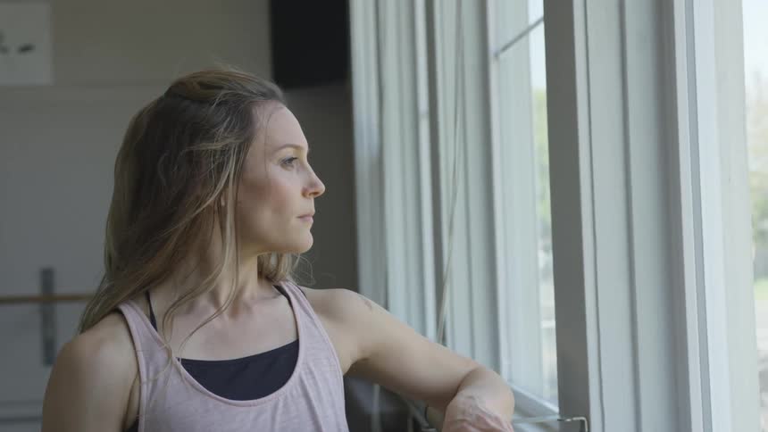 A woman standing and looking out a window