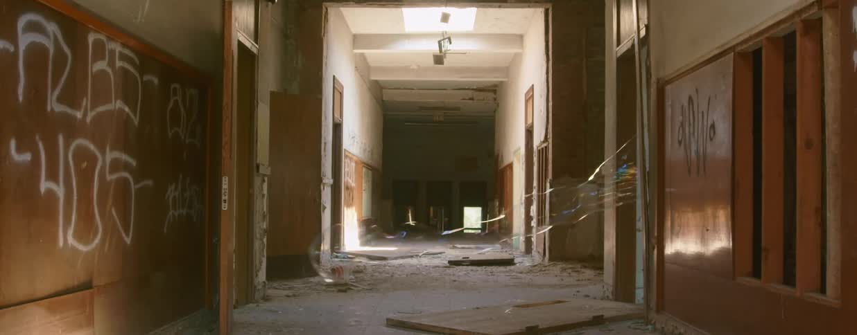 A long soap bubble is blown across the hall of an abandoned building