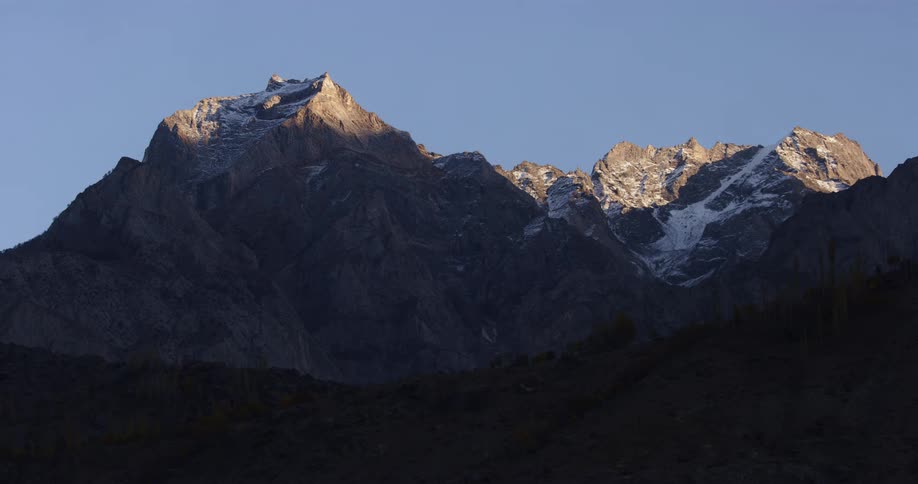 The side of a mountain range becomes hidden as shade covers it