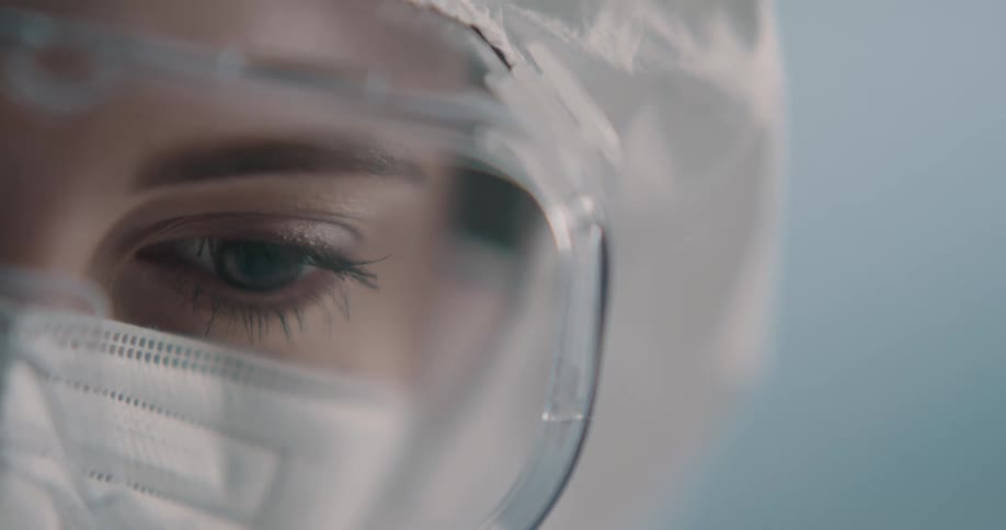 Medical employee wearing goggles mask and hair covering