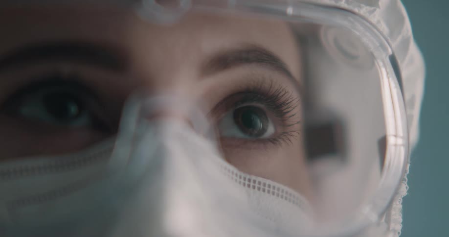 A nurse in a mask goggles and cap