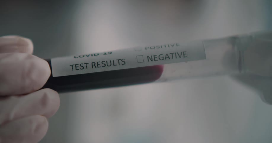 A woman holds a test tube with a lab sample in it