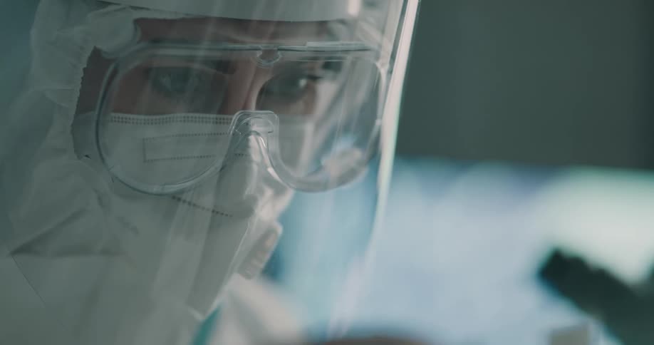 Scientist wearing protective glasses and face shield working on a laboratory
