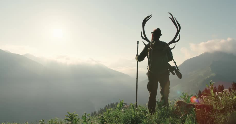 A man is hiking outdoors with his dog