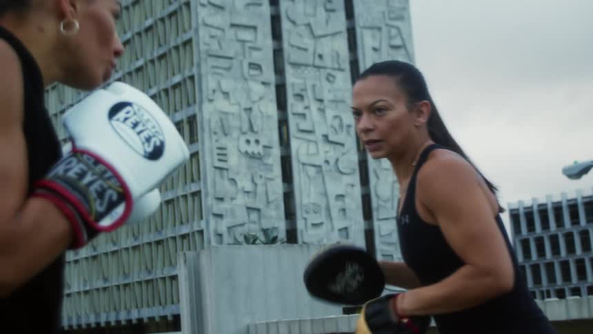 Two women are boxing in a downtown city