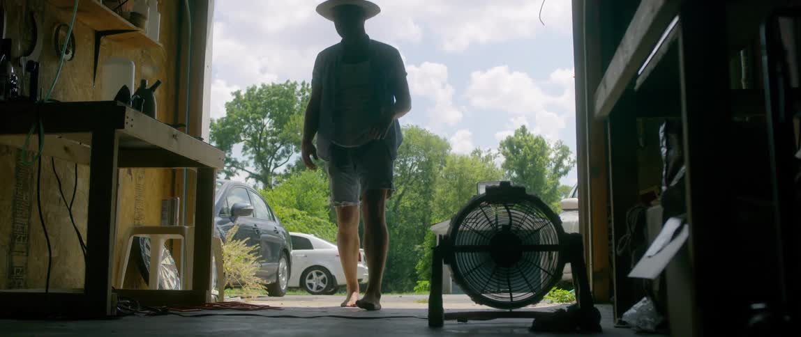 A man opens a garage door and walks inside