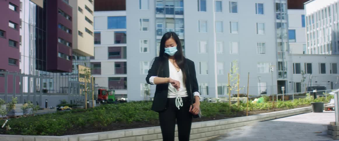 A woman is standing in a downtown city