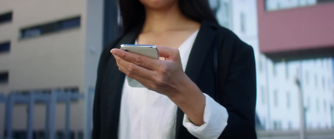 A woman is texting on a cellphone in an urban area