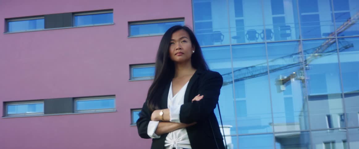 Young woman walks outside modern office building