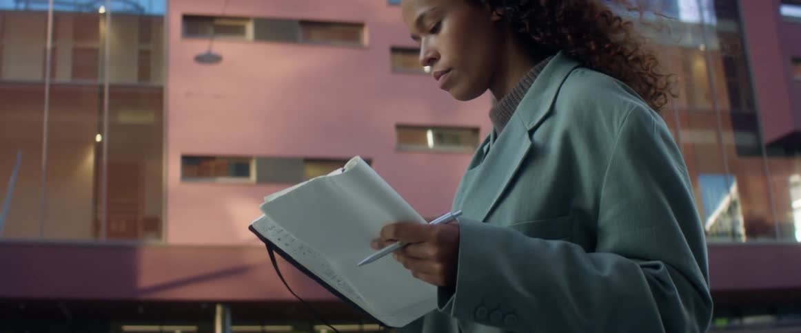 Woman walking in the street of a city takes a smart phone out of her purse