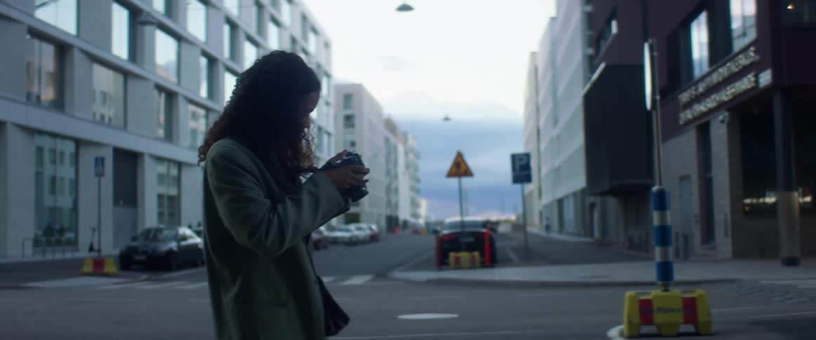 Woman taking picture with film camera on town street