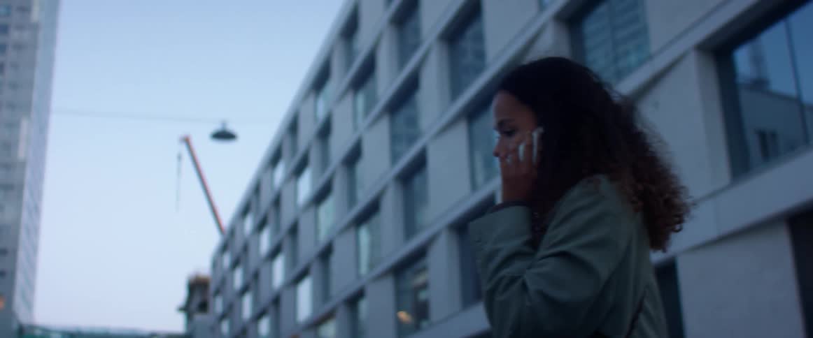 A woman is talking on a cell phone in an urban city