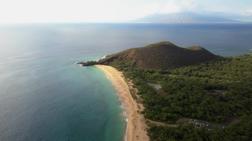 Ocean waves are moving towards the coast of an island