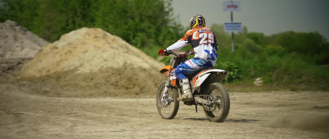A person rides their motorbike on a dirt path