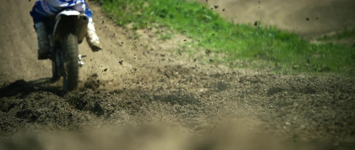 A person rides his dirt bike up the hill
