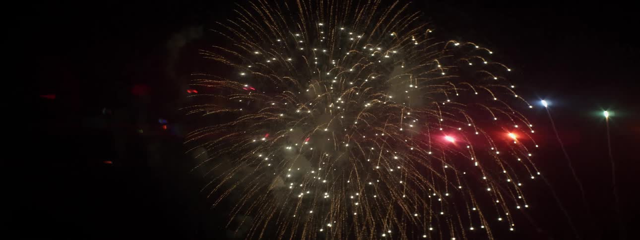 Fireworks exploding in the sky with smoke and lights