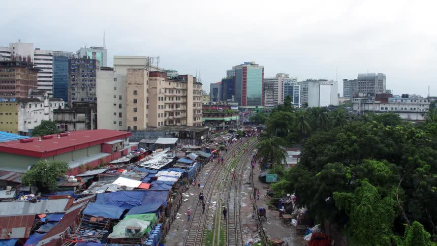 Small shacks sit next to tall apartment buildings in a city in a developing country