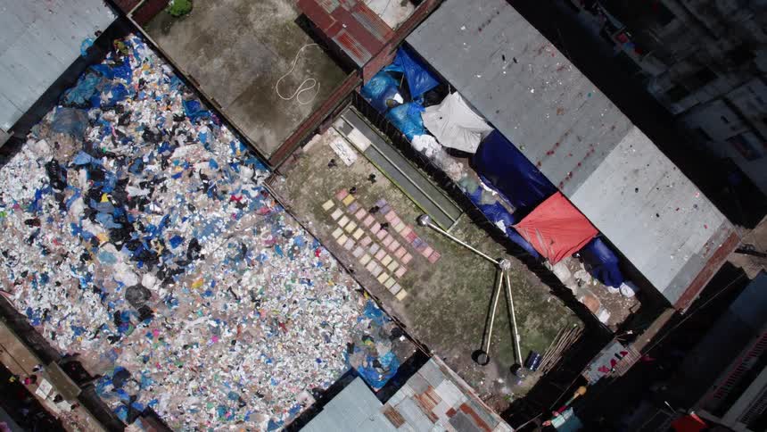 People walking with mats on the floor and garbage on the floor