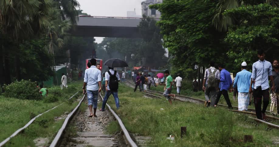 Crowd of people walking over the train tracks near the city