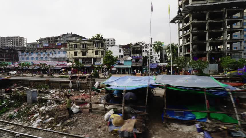 Rundown buildings and makeshift housing in a garbage strewn slum in a city during the day