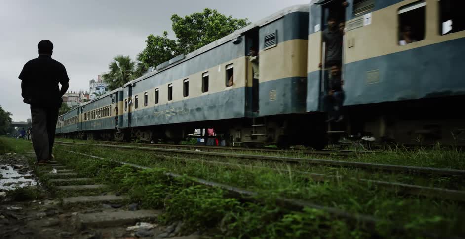 A man walks past the moving train