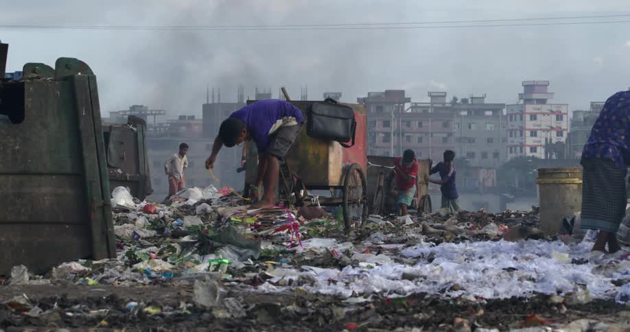 Group of people collecting garbage in a third world landfill