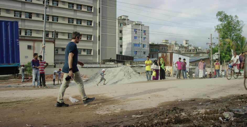 A man walking down a dirt road in a third world nation