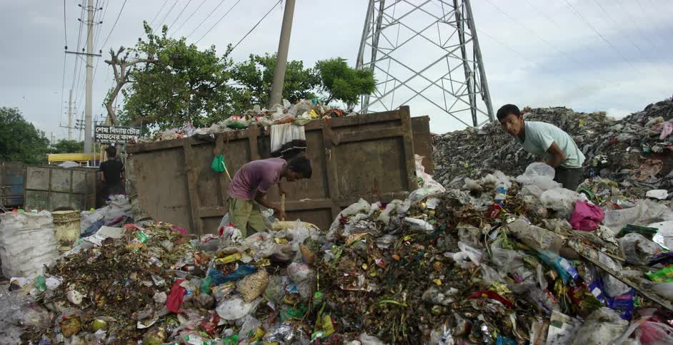 Two men picking garbage in a garbage dump