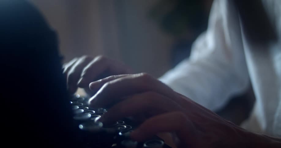 A man is using a typewriter indoors
