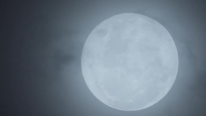 A moon is shining in the night sky