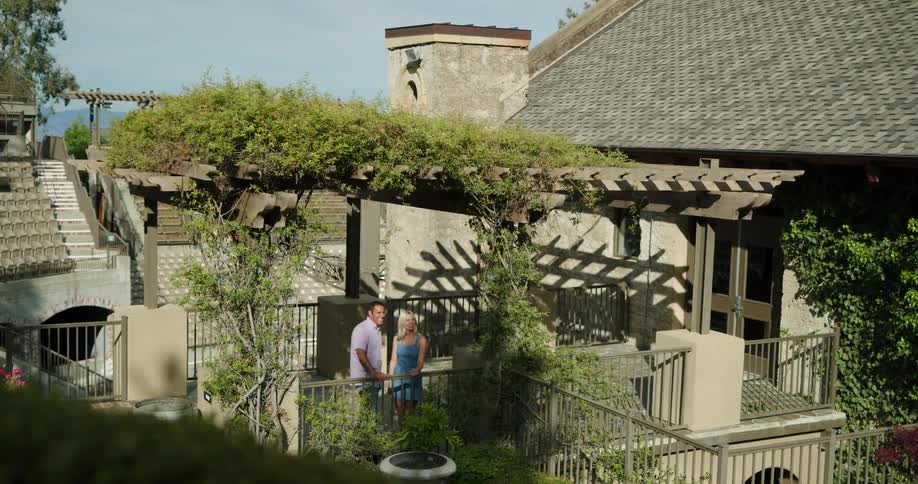 A man and woman on a terrace look out at a skyline