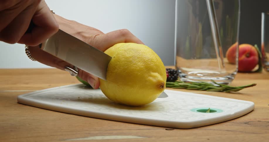 A woman is cutting fruit with a knife