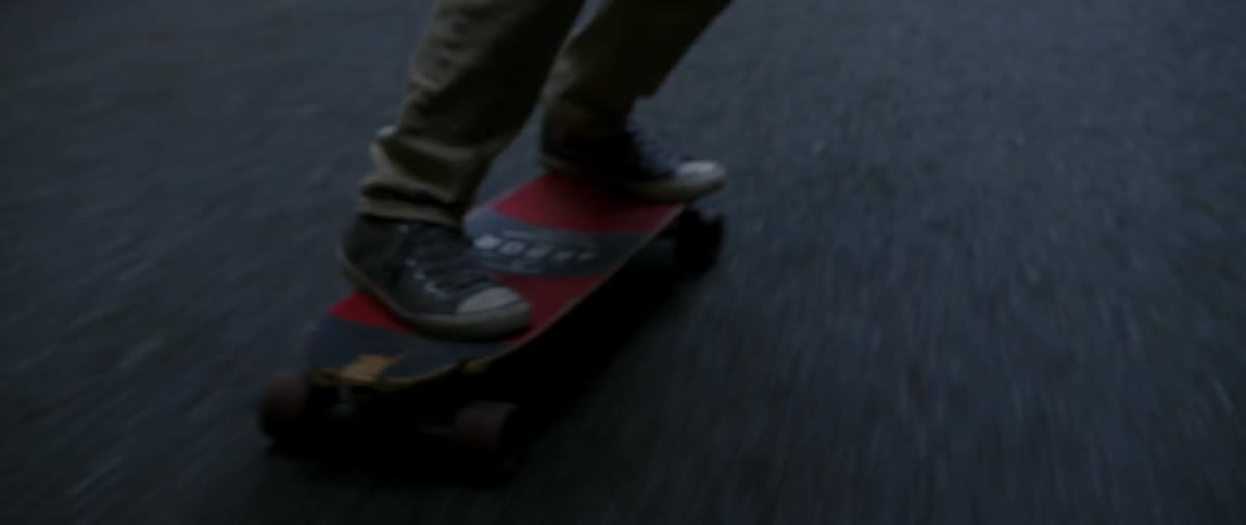Close up a man skateboarding before tripping and falling off while staying on his feet