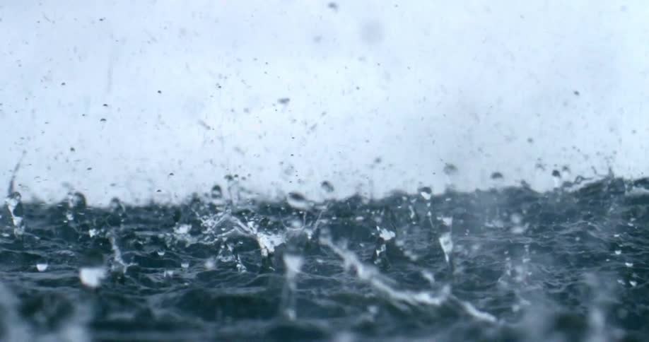 Raindrops hitting ocean water during a rainstorm